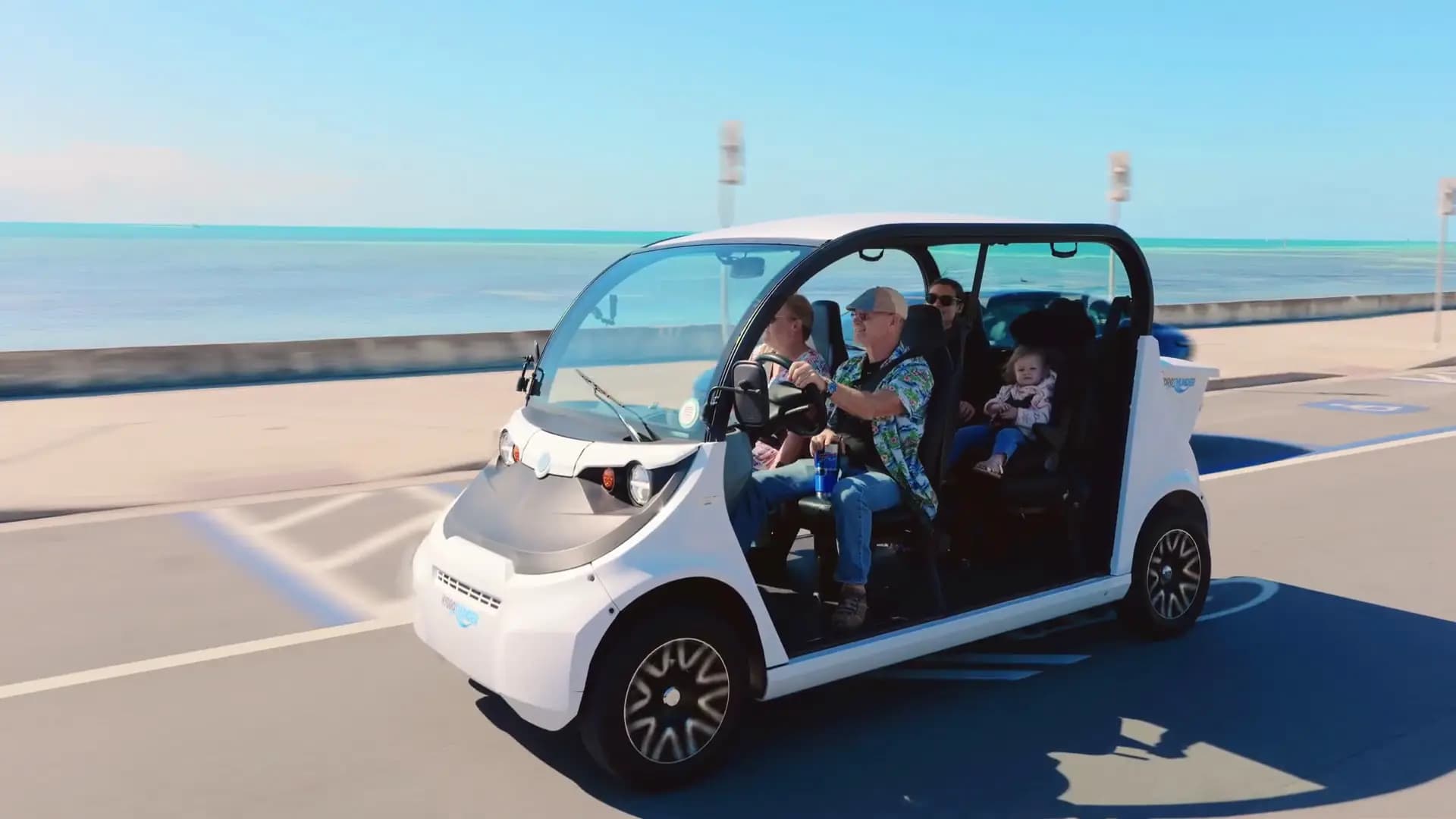 Family enjoying an electric car ride along the waterfront