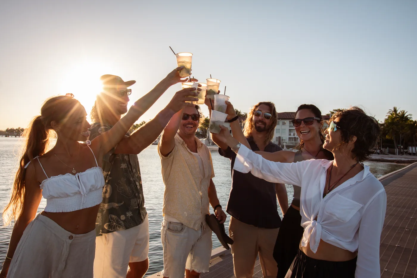 Group toasting at sunset by the water